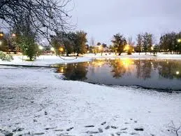 Una vista panorámica nevada de Villa Carlos Paz o una imagen de turistas sacándose fotos con nieve en La Cumbrecita.